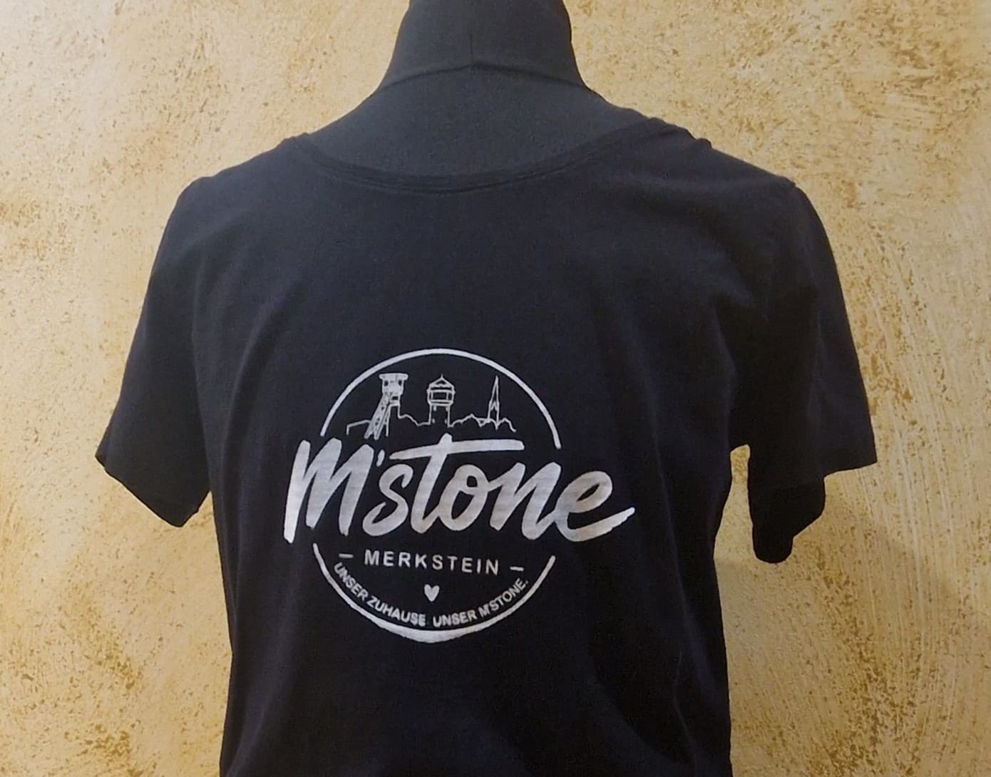 Schwarzes M'stone T-Shirt mit weißem Badge-Print, getragen